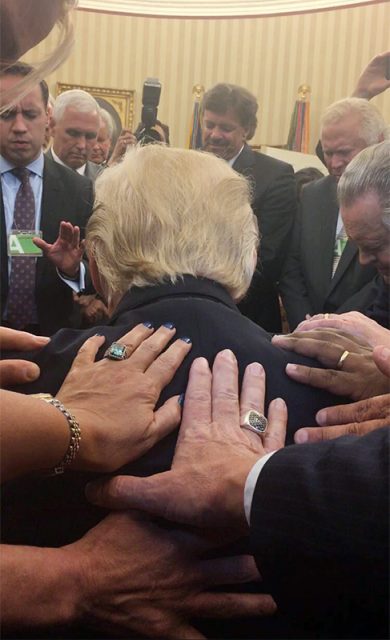 Evangelical supporters place hands on and pray with President Trump in the Oval Office of the White House.  Photo courtesy of Johnnie Moore