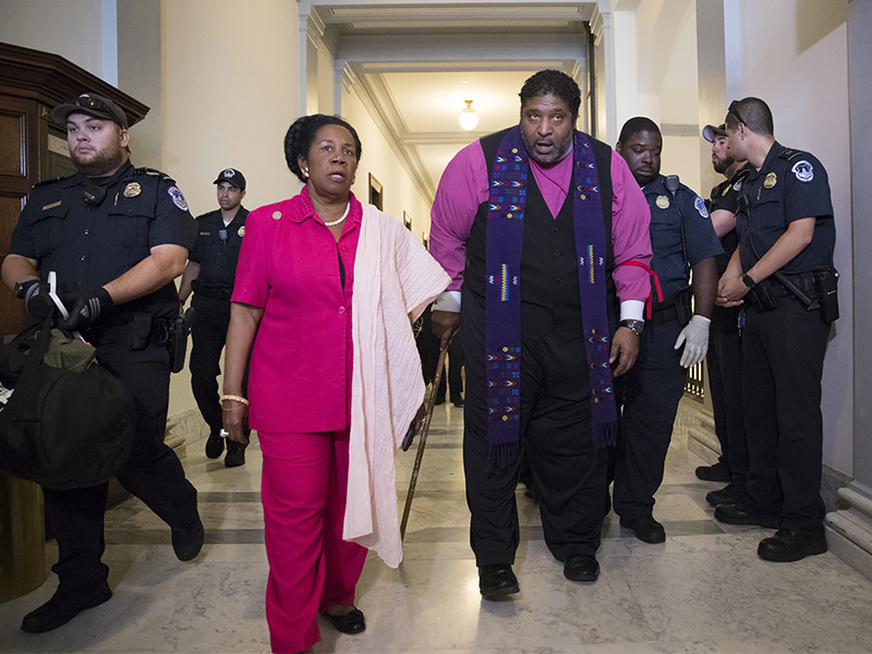 North Carolina NAACP President Rev. William Barber, accompanied by Rep. Sheila Jackson Lee, Texas, left, as activists, many of them clergy, are taken into custody by U.S. Capitol Police on Capitol Hill in Washington, D.C., on July 13, 2017.  The activists were protesting against the Republican health care bill outside the office of Senate Majority Leader Mitch McConnell. (AP Photo/J. Scott Applewhite)