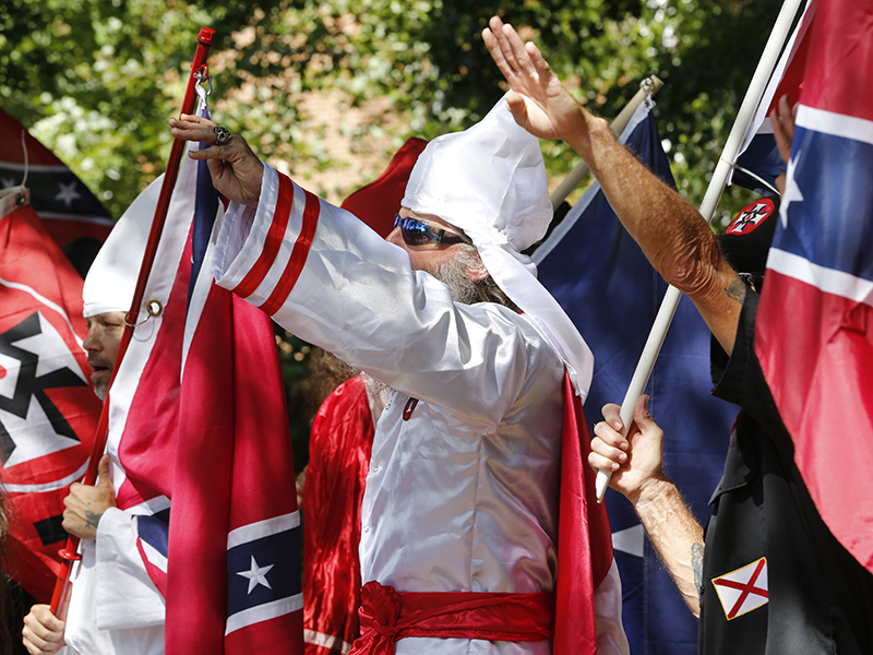 Ku Klux Klan members salute during a KKK rally in Justice Park on July 8, 2017, in Charlottesville, Va. (AP Photo/Steve Helber)