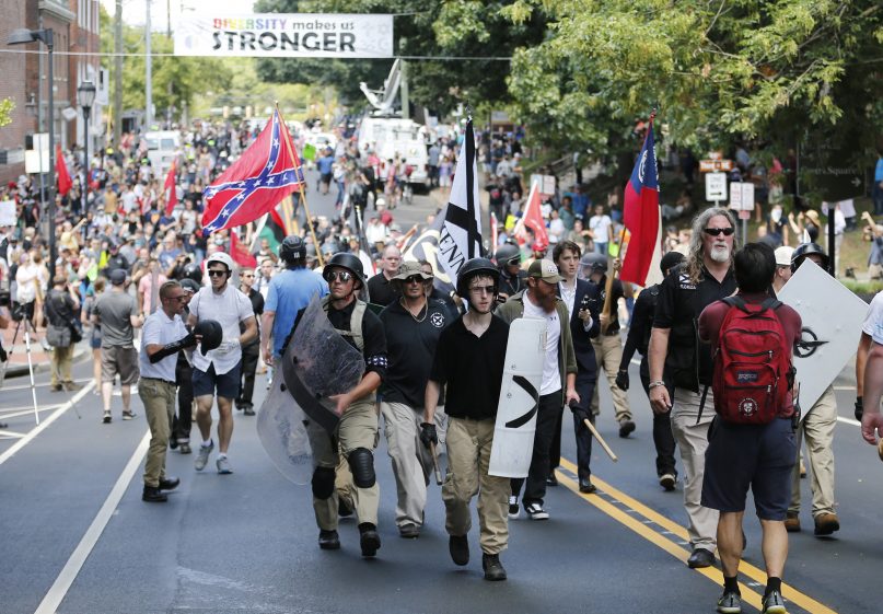 White nationalist demonstrators walk through town after their rally was closed down near Lee Park in Charlottesville, Va., on Aug. 12, 2017. (AP Photo/Steve Helber)