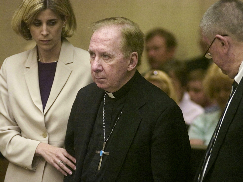 In this March 26, 2004, file pool photo, Bishop Thomas O'Brien, center, is flanked by attorneys, Melissa Berren, left, and Tom Henze, right, as they stand before Judge Stephen Gerst in a courtroom in Phoenix. O'Brien, a former bishop who led the Roman Catholic church in metro Phoenix during a worldwide child sexual abuse scandal, has been accused of molesting a young boy 35 years ago. O'Brien is accused in a lawsuit of sexually abusing the boy on several occasions at parishes in Phoenix and Goodyear from 1977 to 1982. The Diocese of Phoenix says O'Brien denies the allegation. (AP Photo/Mark Henle, Pool, File)
