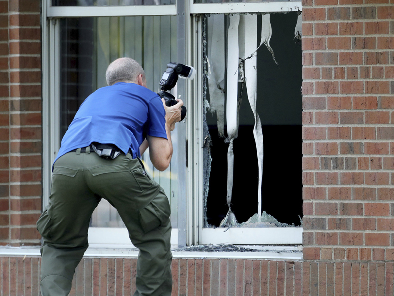 Law enforcement officials investigate an explosion at the Dar Al-Farooq Islamic Center in Bloomington, Minn., on Aug. 5, 2017.   Authorities said the explosion damaged one room but it didn't hurt anyone. (David Joles/Star Tribune via AP)
