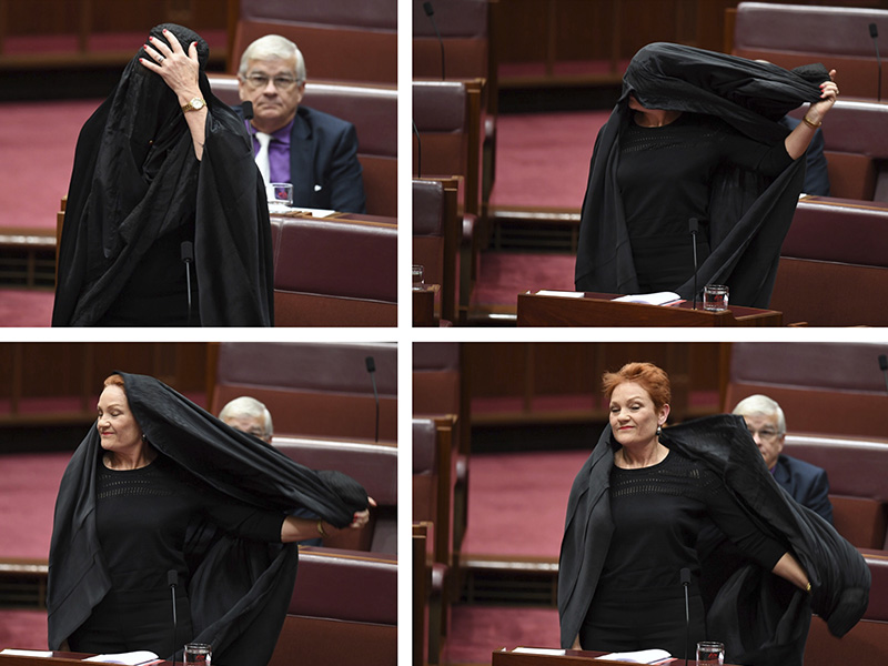 In this combination of photos Sen. Pauline Hanson takes off a burqa she wore into the Senate chamber at Parliament House in Canberra, Australia, on Aug. 17, 2017. Hanson, leader of the anti-Muslim, anti-immigration One Nation minor party, sat wearing the black head-to-ankle garment for more than 10 minutes before taking it off as she rose to explain that she wanted such outfits banned on national security grounds. (Lukas Coch/AAP Image via AP)