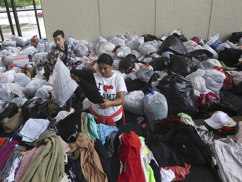 Volunteers Brenda Tcoc, right, and Hugo Wilson help sort bags of donated clothes for victims of the flooding from Tropical Storm Harvey after a shelter opened at the Lakewood Church in Houston, Texas, on Aug. 29, 2017. (AP Photo/LM Otero)