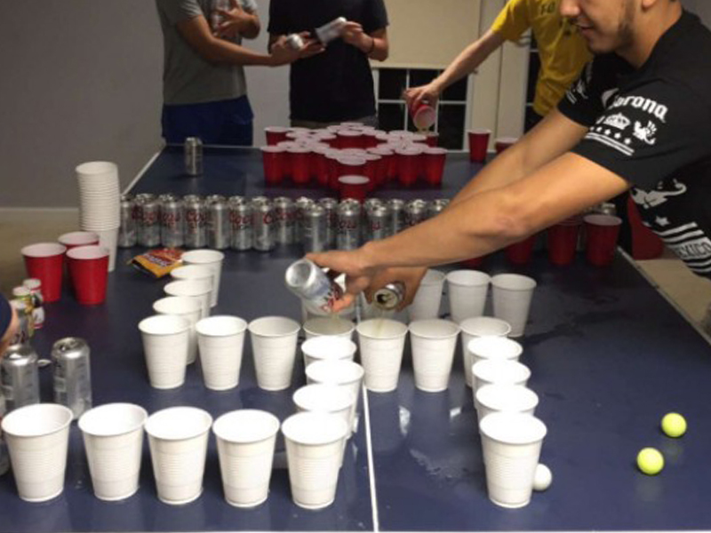 People fill cups with beer for a game of Jews vs. Nazis beer pong.