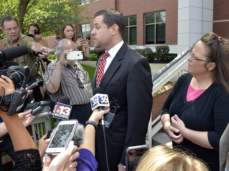 Rowan County Clerk Kim Davis, right, listens as her attorney Roger Gannam addresses the media on the steps of the U.S. District Court for the Eastern District of Kentucky in Covington on July 20, 2015. Davis, who has said she cannot issue marriage licenses to same-sex couples because it would violate her religious beliefs, is being sued by the American Civil Liberties Union on the behalf of two gay couples and two straight couples. (AP Photo/Timothy D. Easley)