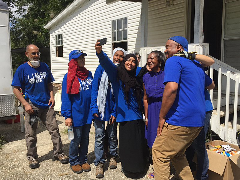 A group of volunteers with Islamic Relief USA take a selfie with Delores J. Porter,whose house was submerged in water after Hurricane Matthew flooded the town of Princeville. RNS photo by Yonat Shimron