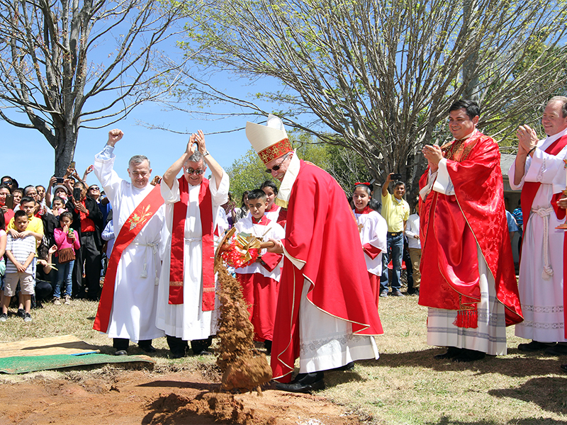 Bishop Luis R. Zarama, center, makes the first ceremonial dirt toss during the April 9, 2017, site blessing and groundbreaking for St. John Paul II Mission’s new church building in Gainesville, Ga. Clergy applauding the moment include (l-r) Deacon Luis L. Londono, Msgr. Jaime Barona, pastor of St. Michael Church in Gainesville, the Rev. Gerardo Ceballos, parochial vicar at St. Michael Church, and Deacon Joel Ballantyne. Photo By Michael Alexander/Georgia Bulletin