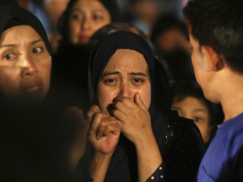Relatives cry during a mass funeral for victims of a school fire outside of Kuala Lumpur, Malaysia, on Sept. 15, 2017. Officials said that the private Islamic boarding school was operating without a fire safety permit and license and that a dividing wall was illegally built on the top floor that blocked the victims from a second exit. (AP Photo/Daniel Chan)