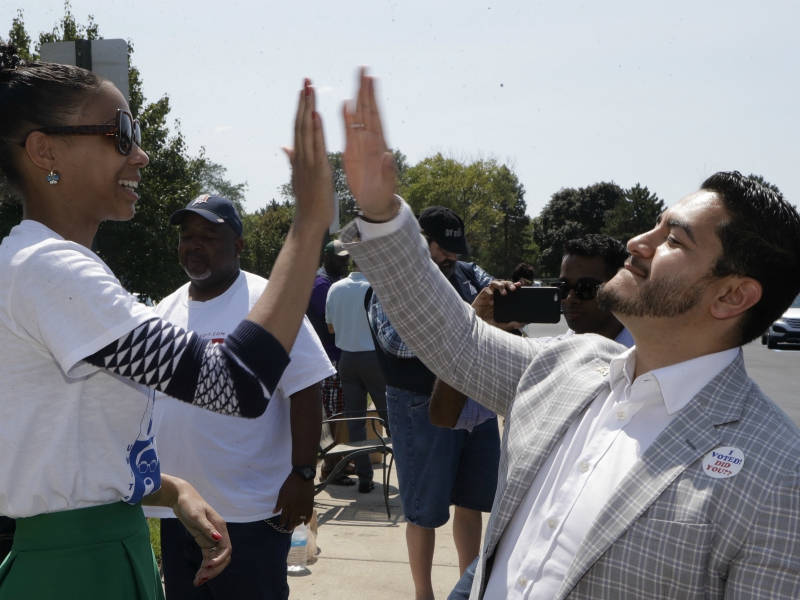 In this Aug. 8, 2017, photo, Dr. Abdul El-Sayed high-fives supporter Sonique Watson in Detroit. Perhaps no state has embraced the political outsider as much as Michigan. El-Sayed, a 32-year-old liberal doctor, is putting that affinity for newcomers to the test by mounting a surprisingly strong bid to become the nation’s first Muslim governor. (AP Photo/Carlos Osorio)