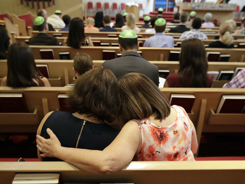 Debbie Uzick, right, puts her arm around Natalie Hausman-Weiss during a Bar Mitzvah on Saturday, Sept. 2, 2017, in Houston. Both of their homes were flooded in the aftermath of Harvey. (AP Photo/David J. Phillip)