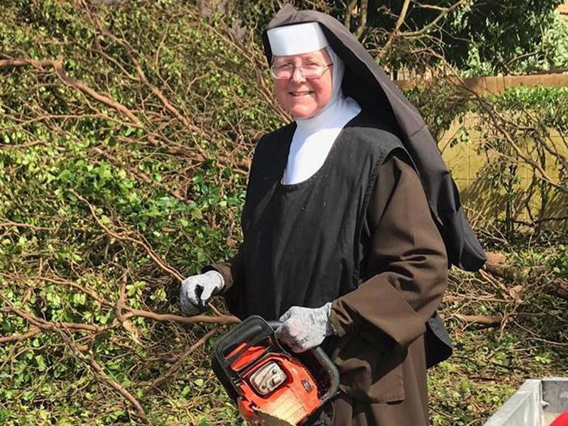 Sister Margaret Ann, the principal of Archbishop Coleman F. Carroll High School, southwest of downtown Miami, wields a chainsaw to clear trees in her neighborhood after Hurricane Irma. Photo courtesy of Miami-Dade Police Department
