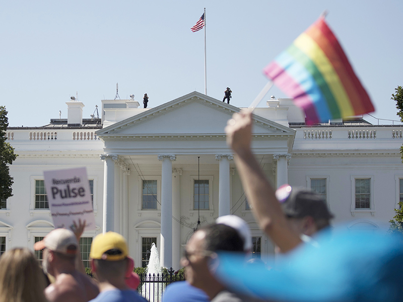In this June 11, 2017, file photo, Equality March for Unity and Pride participants march past the White House in Washington. Many LGBT-rights activists never believed Donald Trump's campaign promises to be their friend. With his move to ban transgender people from military service on  July 26, 2017, on top of other actions and appointments, they now see him as openly hostile. (AP Photo/Carolyn Kaster)