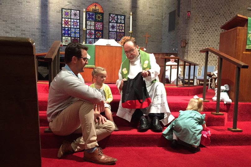 Senior Pastor Wolfgang Herz-Lane gives a Martin Luther toy to a child during a service at Christ the King Lutheran Church in Cary, North Carolina. RNS photo by Yonat Shimron