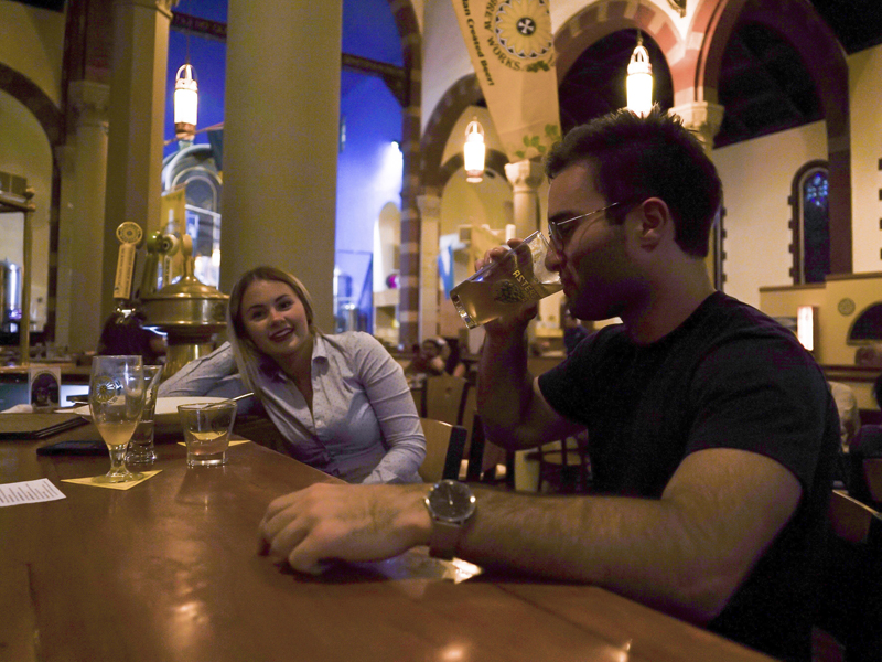 In this Aug. 7, 2017, photo, Jesse Hulien, right, drinks a beer as Molly Hartman, left, looks on, at the Church Brew Works, a former church renovated into a brewery, in Pittsburgh. Breweries opening in renovated churches are winning fans but earning disapproval from clergy and worshippers across the U.S. (AP Photo/Dake Kang)