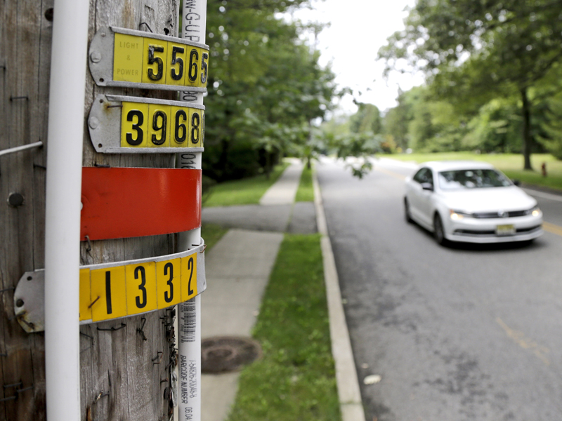 In this Aug. 5, 2017, file photo, in Mahwah, N.J., a vehicle drives past red piping attached to a utility pole, signifying an outdoor area known as an eruv used by Orthodox Jews to mark areas where they are permitted to carry items while observing Sabbath rules against work. The Mahwah town council tried to ban eruvs and to limit a public park to residents -- keeping out chiefly Jewish neighbors from New York.  (AP Photo/Julio Cortez, File)