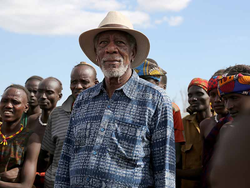 Omo Valley, Ethiopia - Morgan Freeman looks off into the distance as  Ethiopian villagers line up behind him during the Ethiopian Peace Ceremony in Omo Valley, Ethiopia. National Geographic/Maria Bohe 