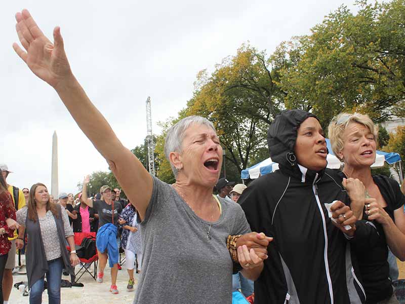 Women prayed for racial reconciliation at the “Rise Up” prayer rally on Oct. 9, 2017, in Washington, D.C. Left to right are Beth Defrance of Colorado Springs, Colo., Akiliah Manuel Mills of Riverside, Calif., and Valerie Jungck of Colorado Springs, Colo. RNS photo by Adelle M. Banks