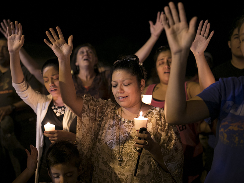 Mourners participate during a candlelight vigil held for the victims of a fatal shooting at the First Baptist Church of Sutherland Springs, Sunday, Nov. 5, 2017, in Sutherland Springs, Texas. (Jay Janner/Austin American-Statesman via AP)