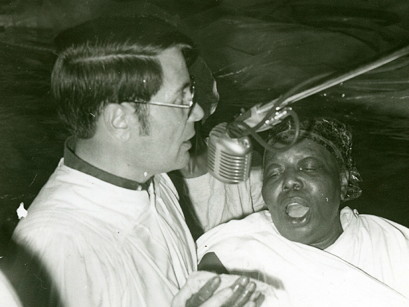 (RNS4-MAY26) The Rev. Jim Jones performs a baptism in the swimming pool at Peoples Temple church in Redwood Valley, Calif. (circa 1973). See RNS-JONESTOWN-PLAY, transmitted May 26, 2005. Photo courtesy of California Historical Society.