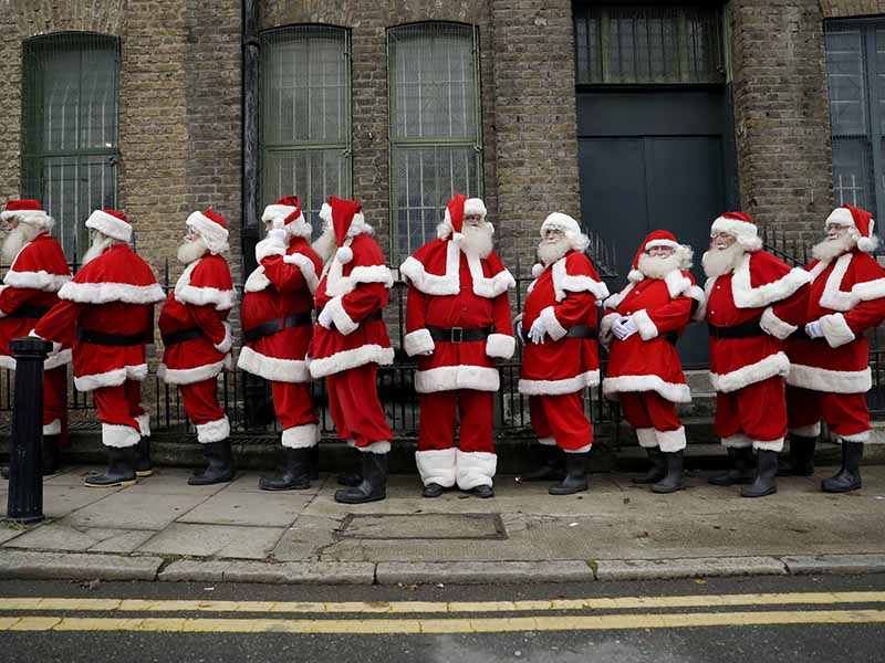 Performers dressed as Santa Claus stand posed in a line during a photocall for the media for the Ministry of Fun Santa School outside the Ragged School Museum in east London, Thursday, Nov. 16, 2017. The Ministry of Fun Santa School is Britain's only genuine training school for professional Santas, preparing them to help out in grottos, department stores, attractions and events over the Christmas period. (AP Photo/Matt Dunham)