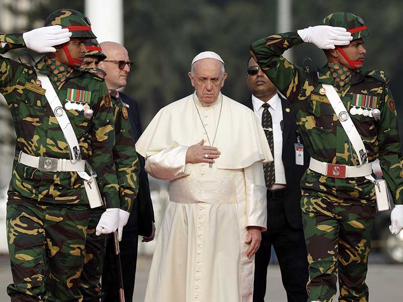 Pope Francis reviews an honor guard as he arrives at Dhaka's international airport, Bangladesh, on Nov. 30, 2017. (AP Photo/Andrew Medichini)
