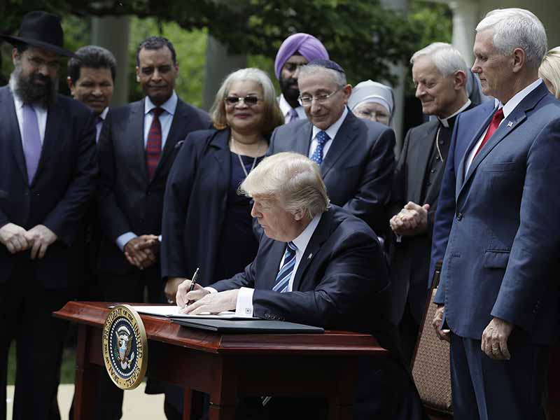 President Trump signs an executive order in the Rose Garden of the White House in Washington on May 4, 2017, asking the IRS to use 