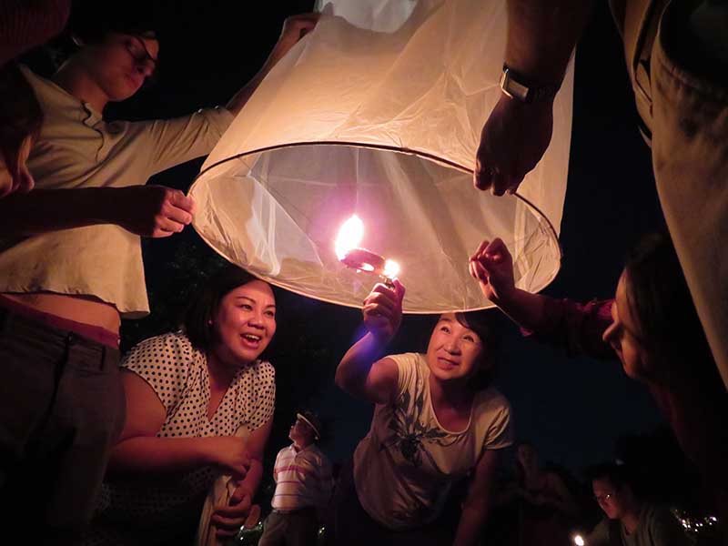 People light a sky lantern, or khom loy, to release along the Ping River during the Chiang Mai Yee Peng and Loy Krathong Festivals on Nov. 3, 2017, in northern Thailand. RNS photo by Kit Doyle