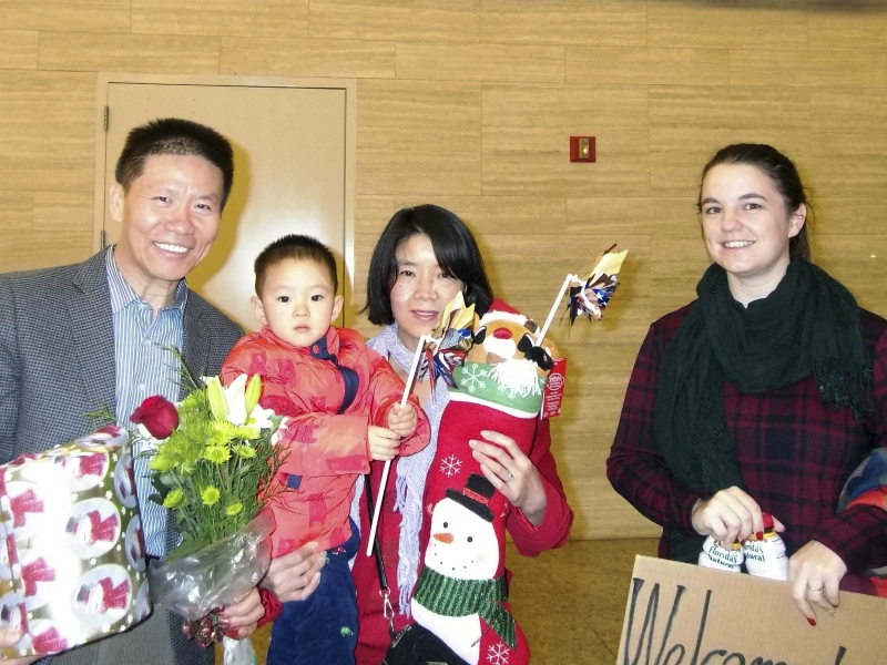 In this Dec 24, 2017 photo, Li Aijie, center in red with her son Li Mutian, poses for a photo with Bob Fu of China Aid at left and Kendra Willard, at right from the family hosting the mother and son in Midland, Texas. Li seeks political asylum in the U.S. while her husband serves decades in a Chinese prison for his views on China's treatment of Muslims. (China Aid via AP)