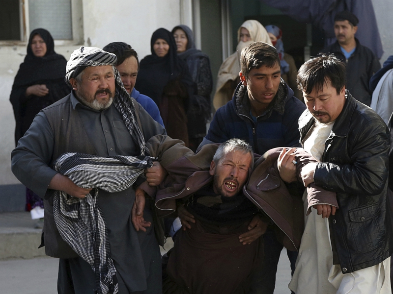 An Afghan man, center, cries as he's pulled away from the scene of a suicide attack in Kabul, Afghanistan, Thursday, Dec. 28, 2017. (AP Photo/Rahmat Gul)