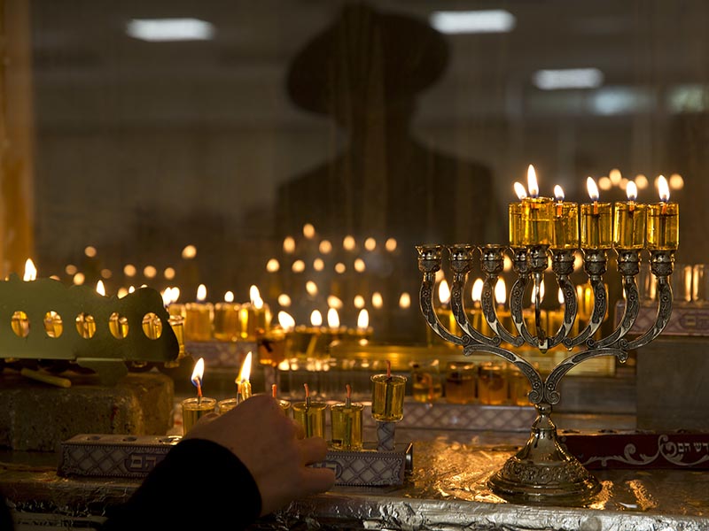 An ultra-Orthodox Jewish man lights candles during the Jewish holiday of Hanukkah in Bnei Brak, near Tel Aviv, Israel, on  Dec. 28, 2016. Hanukkah, also known as the Festival of Lights, is an eight-day commemoration of the Jewish uprising in the second century B.C. against the Greek-Syrian kingdom, which had tried to put statues of Greek gods in the Jewish Temple in Jerusalem. (AP Photo/Ariel Schalit)