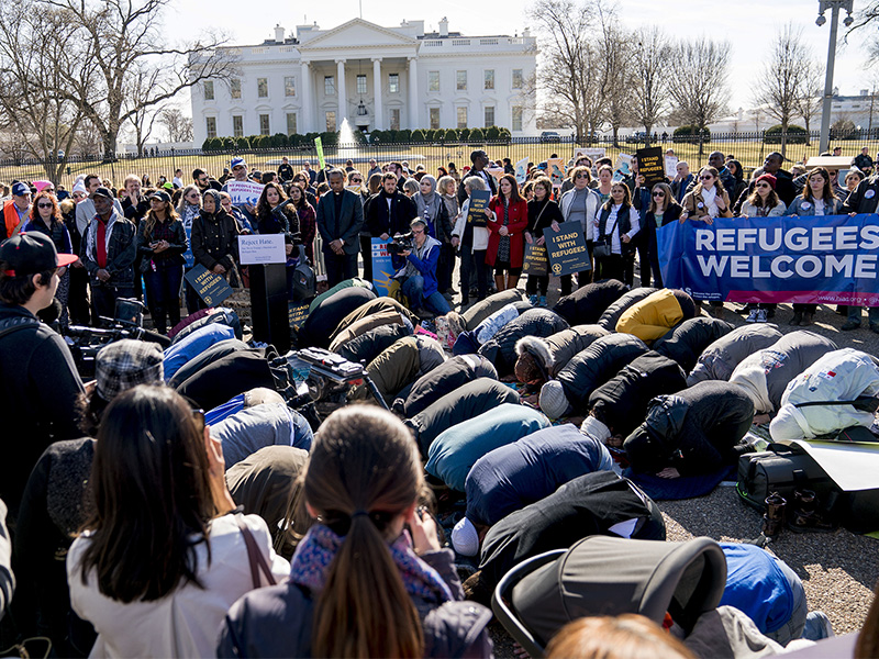 Supporters surround a group who perform the Islamic midday prayer outside the White House in Washington, on Jan. 27, 2018, during a rally on the one-year anniversary of the Trump Administration's first partial travel ban on citizens from seven Muslim majority countries. (AP Photo/Andrew Harnik)