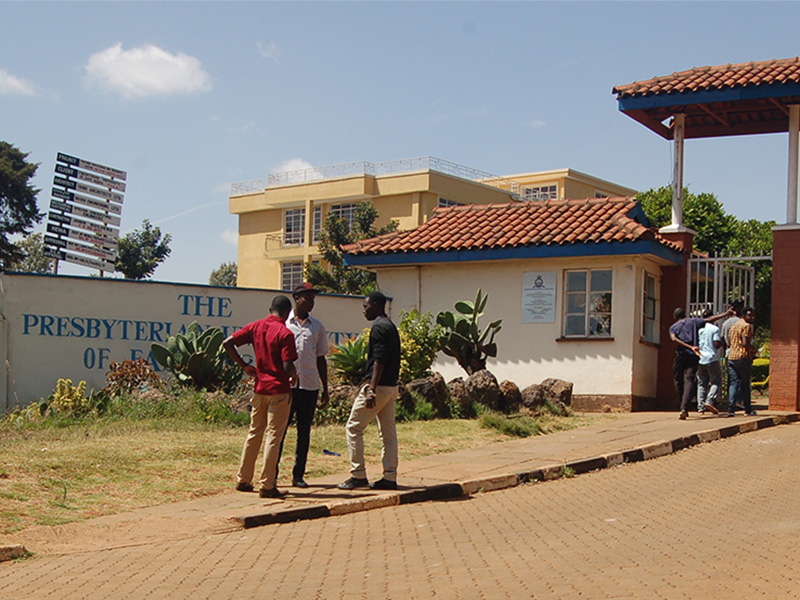 Men stand outside the main entrance of the Presbyterian University of Eastern Africa on Jan. 30, 2018, in Githunguri, Kenya. Kenya’s minister for education ordered the university closed at the recommendation of the regulatory body, the Commission for University Education. RNS photo by Fredrick Nzwili