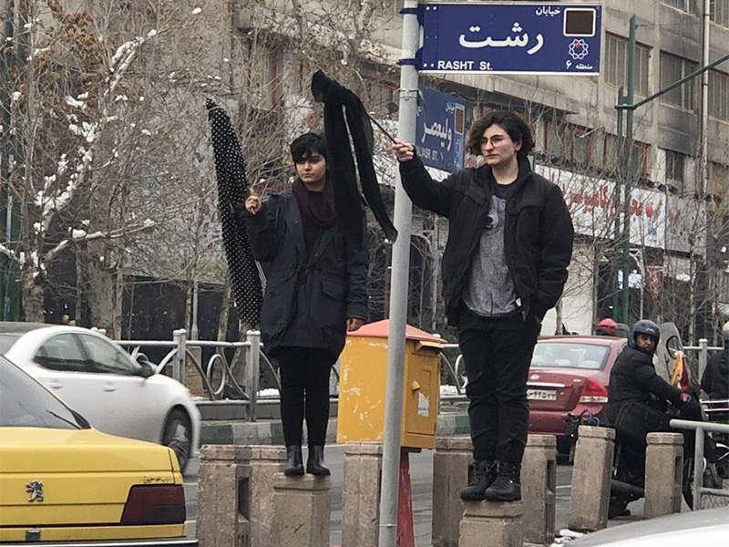 Two women hold scarves on sticks to protest wearing an obligatory Muslim headscarf in Tehran, Iran, on Jan. 30, 2018. Photo via @Vahid/Twitter