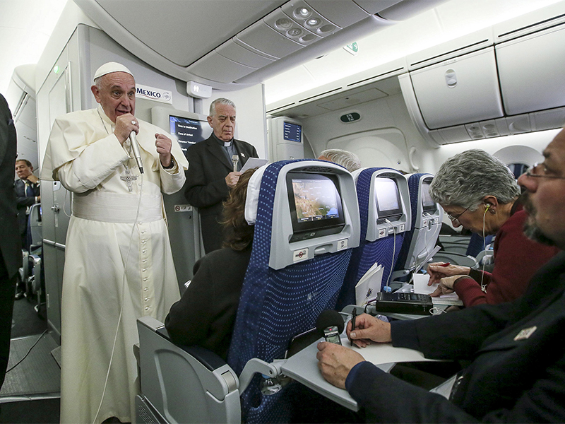 Pope Francis gestures during a meeting with the media onboard the papal plane while en route to Rome on Feb. 17, 2016. Photo by Alessandro Di Meo/Reuters
