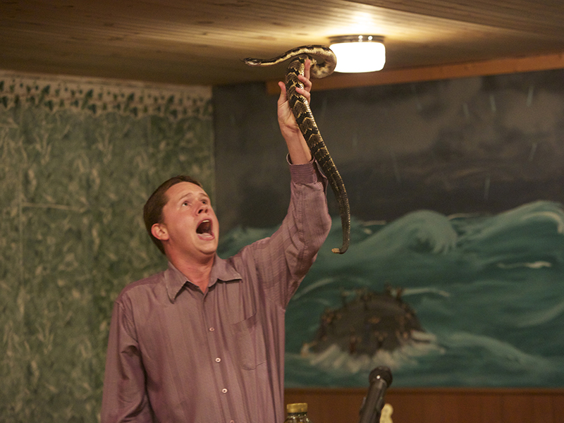 Andrew Hamblin preaches while holding a snake above his head in LaFollette, Tenn. Photo courtesy of National Geographic Channels