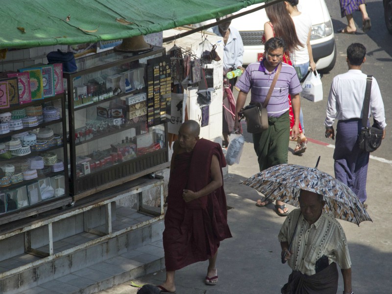Pedestrians including a Buddhist monk walk past a shop selling Islamic religious items Jan. 26, 2018, in Yangon, Myanmar. (AP Photo/Thein Zaw; caption amended by RNS)