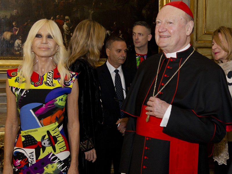 Cardinal Gianfranco Ravasi and designer Donatella Versace arrive at Palazzo Colonna in Rome, Monday, Feb. 26, 2018.  The Vatican is loaning some of its most beautiful liturgical vestments, jeweled miter caps and historic papal tiaras for an upcoming exhibit on Catholic influences in fashion at the Metropolitan Museum of Art. The Vatican culture minister, Cardinal Gianfranco Ravasi, joined Vogue Editor-in-Chief Anna Wintour and designer Donatella Versace in Rome on Monday to display a few of the Vatican treasures at the Palazzo Colonna, a onetime papal residence. 