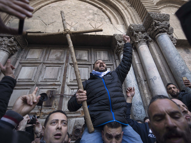 Demonstrators protest outside the closed doors of the Church of the Holy Sepulchre, traditionally believed by many Christians to be the site of the crucifixion and burial of Jesus Christ, in Jerusalem, on Feb. 27, 2018. Jerusalem's mayor suspended a plan to impose taxes on properties owned by Christian churches, backing away from a move that had enraged religious leaders and led to the closure of the Church of the Holy Sepulchre. (AP Photo/Tsafrir Abayov)