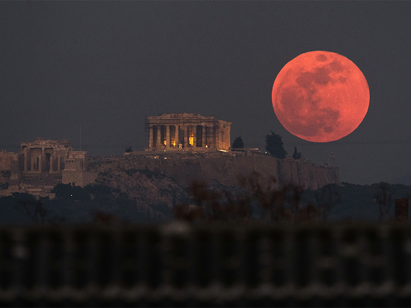 A super blue blood moon rises behind the 2,500-year-old Parthenon temple on the Acropolis of Athens, Greece, on Wednesday, Jan. 31, 2018. On Wednesday, much of the world saw not only a blue moon which is a supermoon, but also a lunar eclipse, all rolled into one celestial phenomenon. (AP Photo/Petros Giannakouris)