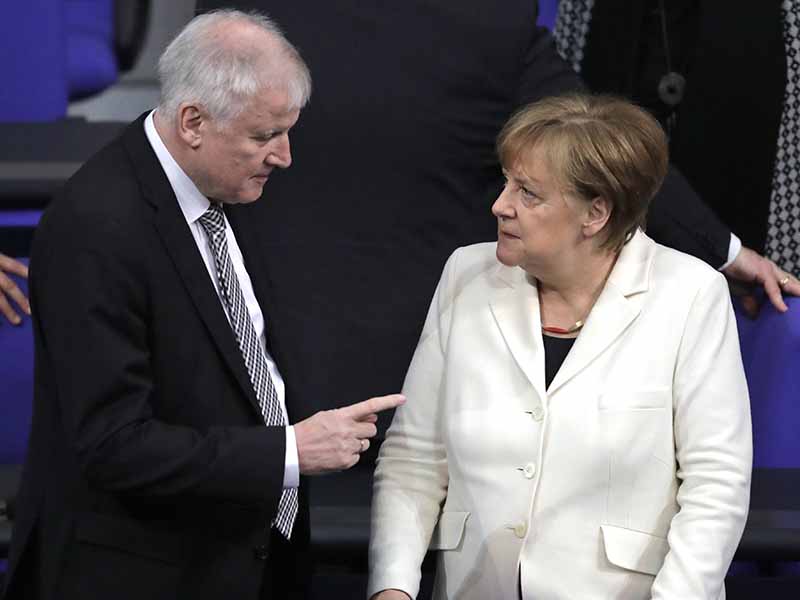 In this March 14, 2018, file photo, German Interior Minister Horst Seehofer talks to Chancellor Angela Merkel  in the German Parliament in Berlin. Germany’s new interior minister is positioning himself to the right of Merkel on migration, telling a newspaper on March 16, 2018, that Islam is not a part of Germany. (AP Photo/Markus Schreiber,file)