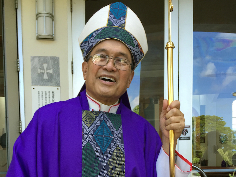 This November 2014 file photo shows Archbishop Anthony Apuron standing in front of the Dulce Nombre de Maria Cathedral Basilica in Hagatna, Guam. (AP Photo/Grace Garces Bordallo, File)