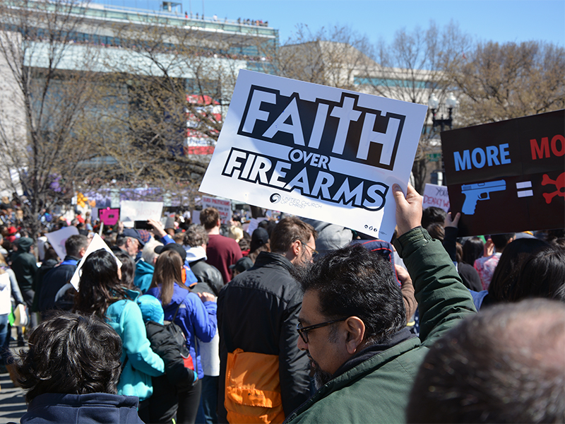 A faith-based protester holds aloft a sign at the March for Our Lives demonstration in Washington, D.C. on March 24, 2018. RNS photo by Jack Jenkins.