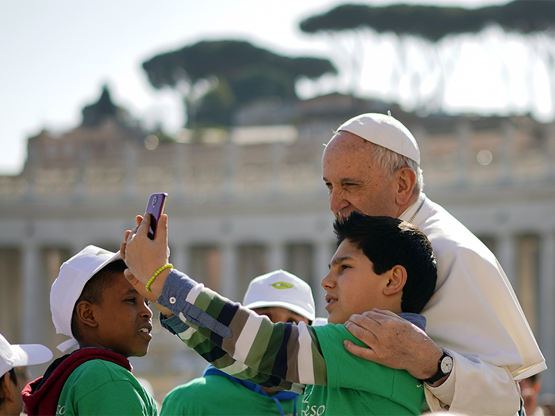 A boy takes a selfie with Pope Francis as he arrives in St. Peter's Square for his general weekly audience at the Vatican on March 14, 2018. March 13 was the five-year anniversary of Pope Francis’ election as bishop of Rome. (AP Photo/Andrew Medichini)