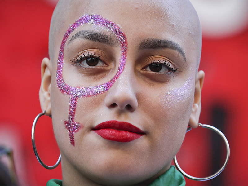 A pro-abortion activist with a Venus symbol painted on her face listens to a speech outside of Congress after the presentation of an abortion bill in Buenos Aires, Argentina, on March 6, 2018. Under heavy pressure by women's groups that have taken to the streets in large numbers in recent years, over 70 legislators presented an abortion bill that will be first be discussed in several committees of the lower chamber. (AP Photo/Victor R. Caivano)