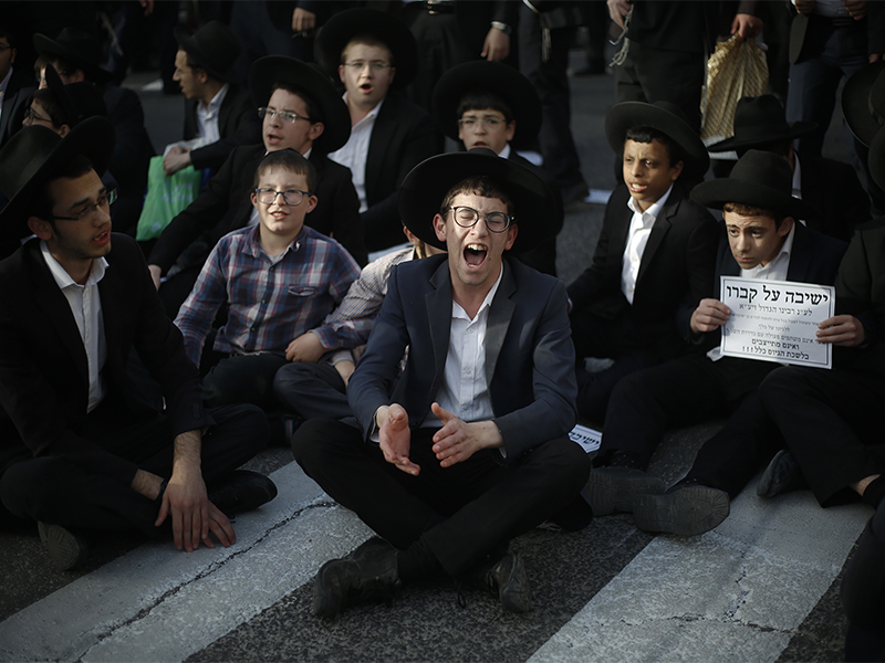 Ultra orthodox Jewish boys join a military draft protest and block an entrance to Jerusalem on March 8, 2018. Israel has compulsory military service for most Jewish men, but the ultra-Orthodox, whose political parties enjoy an outsized role in the country's coalition politics, have secured exemptions. Authorities still require ultra-Orthodox men to register for the draft, something the protesters gathered to oppose. (AP Photo/Ariel Schalit)