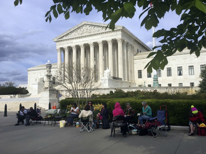 In this April 23, 2018, photo, people wait in line outside the Supreme Court in Washington to be in the gallery when the court hears arguments on April 25 over President Trump’s ban on travelers from several mostly Muslim countries. (AP Photo/Jessica Gresko)