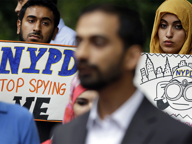 People hold signs at a rally to protest New York Police Department surveillance tactics near police headquarters in New York on Aug. 28, 2013. An audit conducted by Inspector General Philip Eure, found that New York Police Department chronically skirted rules intended to protect political groups from unwarranted government surveillance while investigating Muslims. (AP Photo/Seth Wenig)