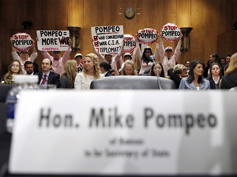 Protesters hold signs up in opposition of the nomination of Mike Pompeo, to be the next secretary of state, at the start of a Senate Foreign Relations Committee confirmation hearing on Pompeo's nomination on Capitol Hill in Washington, on , April 12, 2018. (AP Photo/Jacquelyn Martin)