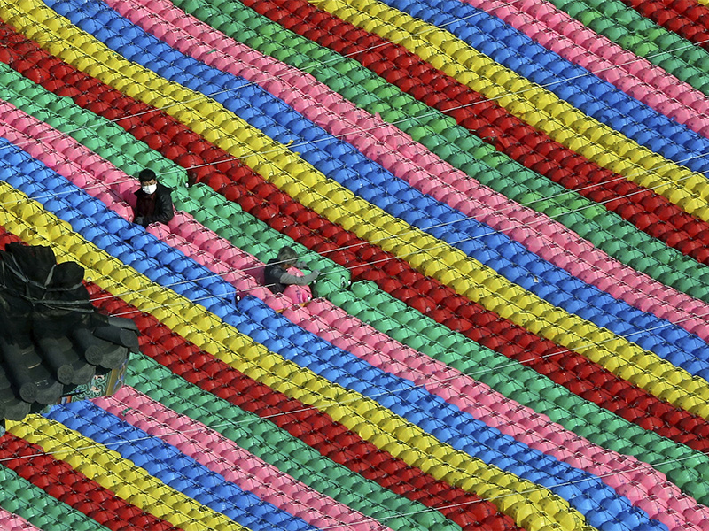 Workers adjust lanterns for upcoming celebration of Buddha's birthday on May 22 at Jogye temple in Seoul, South Korea, on April 17, 2018. (AP Photo/Ahn Young-joon)